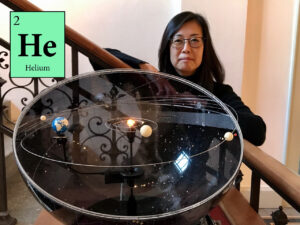 Portrait of Prof. Dr. Sasaki. In front of her is a model of the solar system.