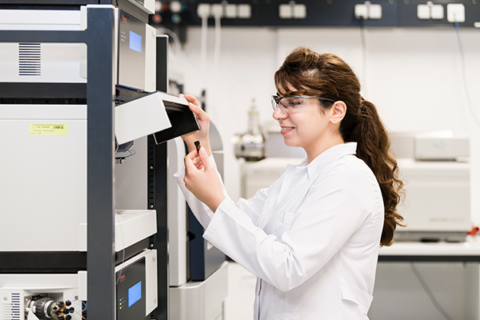 A young woman works at a food chemistry laboratory.